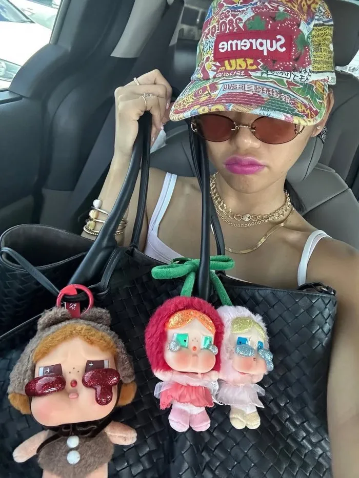 Mimi anuncia una nueva tendencia... ¡llaveros de muñecos colgando de su bolso llaman la atención!